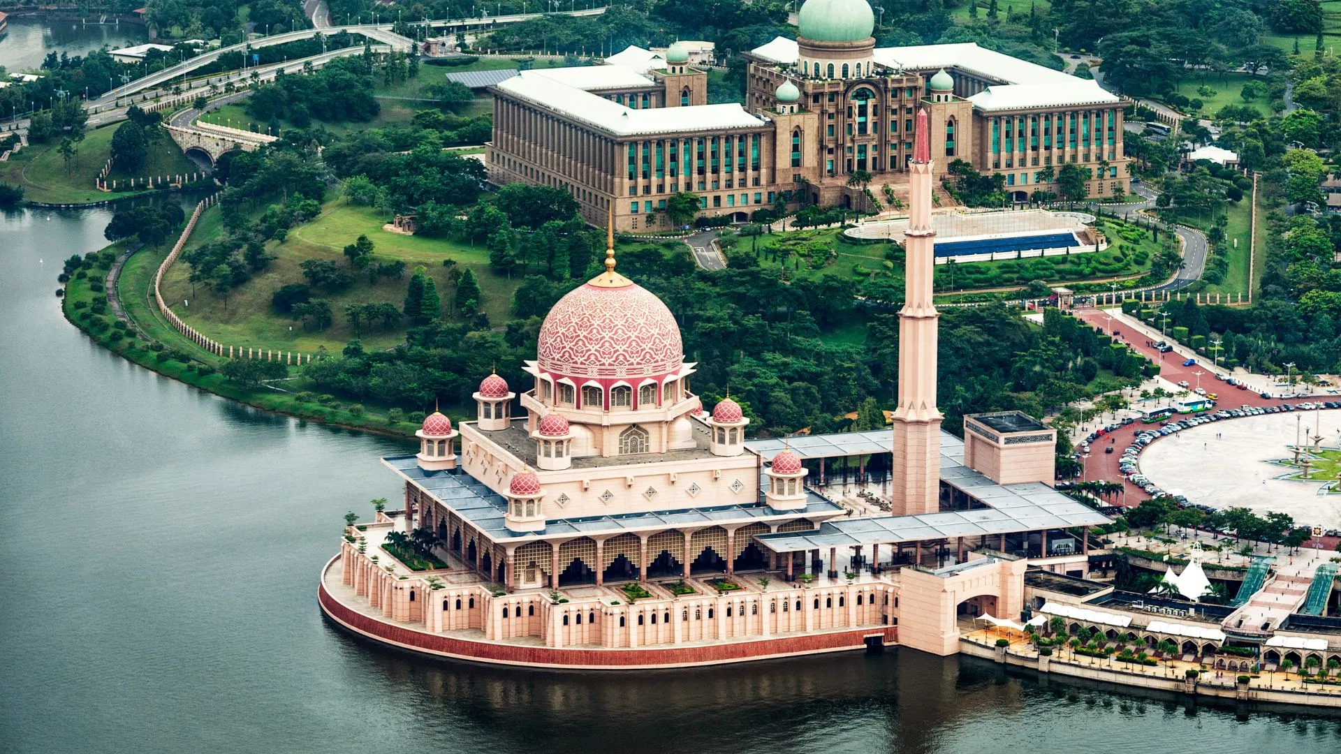 The Putra Mosque on Putrajaya Lake with Perdana Putra on the rise behind it, from the air